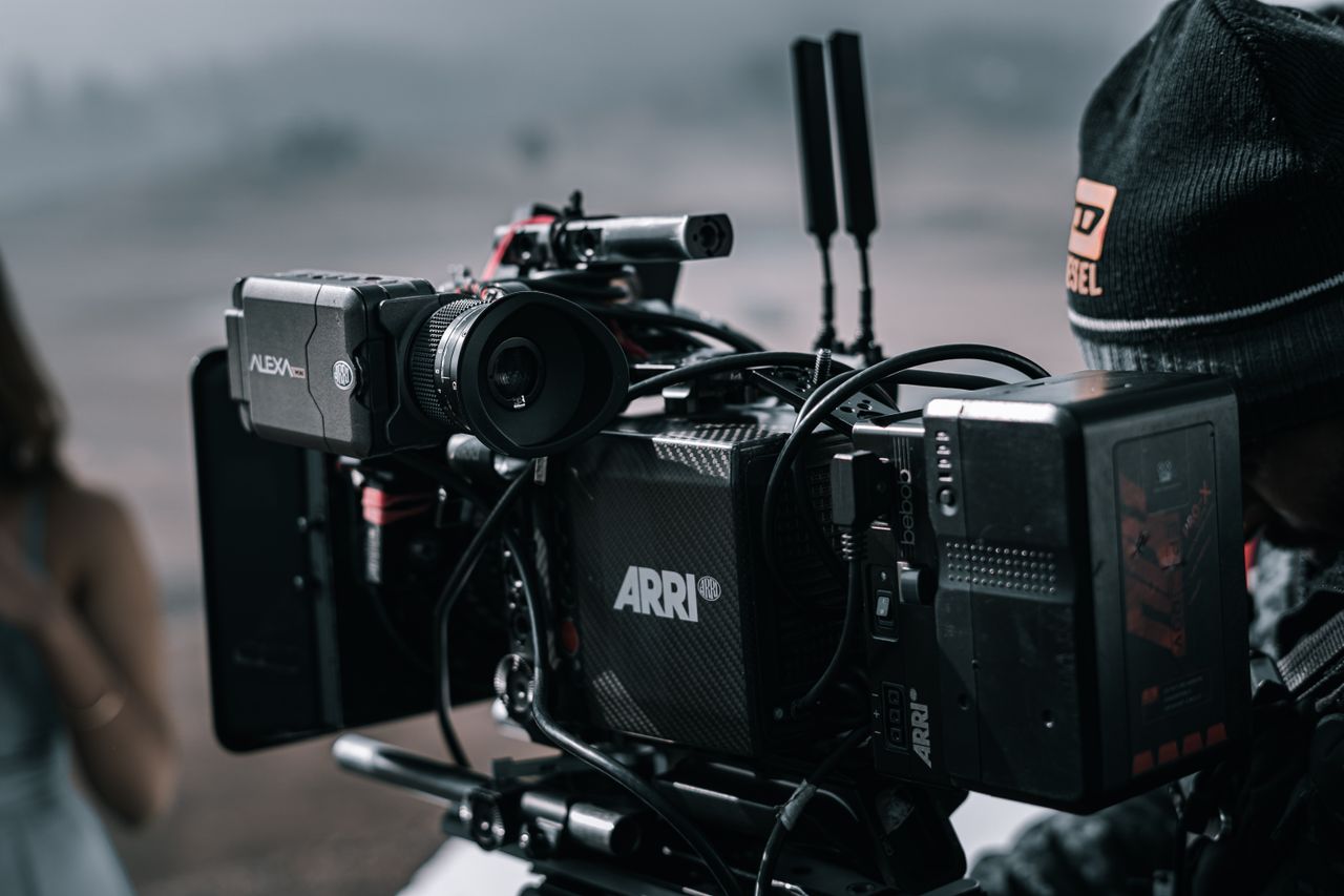 Mastering the First Impression: Your intriguing post title goes here Close-up of a professional filmmaking camera setup on an outdoor set with blurred background.